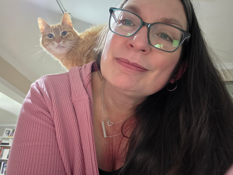 Kim with a cat on her shoulder